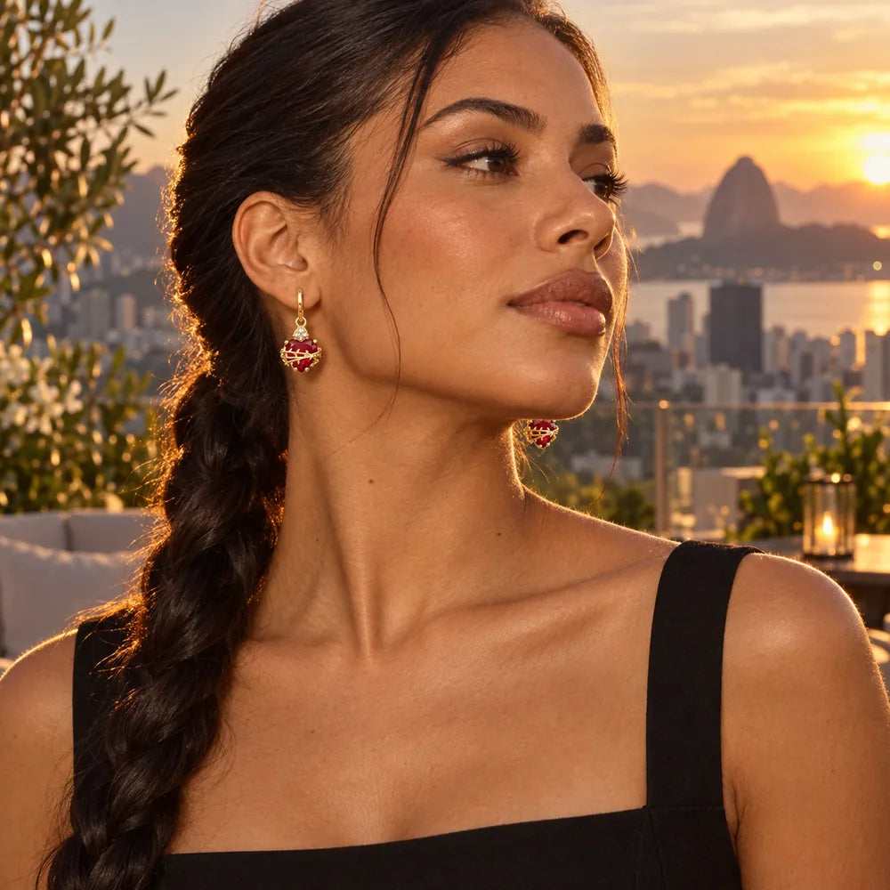 Brinco Sagrado Coração Cor Iesu banhado a ouro em modelo no terraço ao pôr do sol