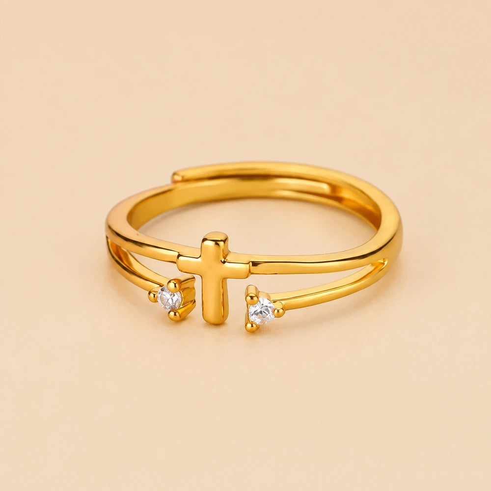 Anel cruz ajustável dourado com zircônias em fundo nude bege Soul Fé